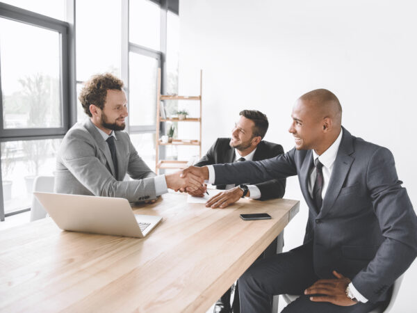 multiethnic smiling businessmen shaking hands